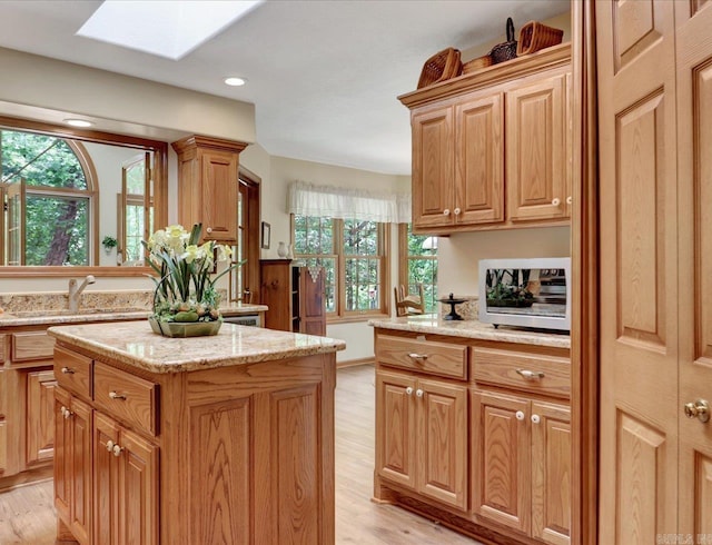 21 Conquista Ln, Hot Springs Village, AR 71909 - kitchen with a skylight, light wood-style floors, a sink, light stone countertops, and recessed lighting