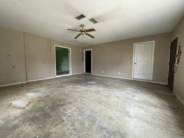 1602 Harmon Dr, Benton, AR 72015 - empty room with ceiling fan, unfinished concrete floors, a textured ceiling, baseboards, and attic access