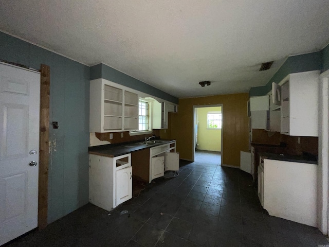 1602 Harmon Dr, Benton, AR 72015 - kitchen featuring a sink, dark countertops, white cabinets, open shelves, and dark tile patterned floors