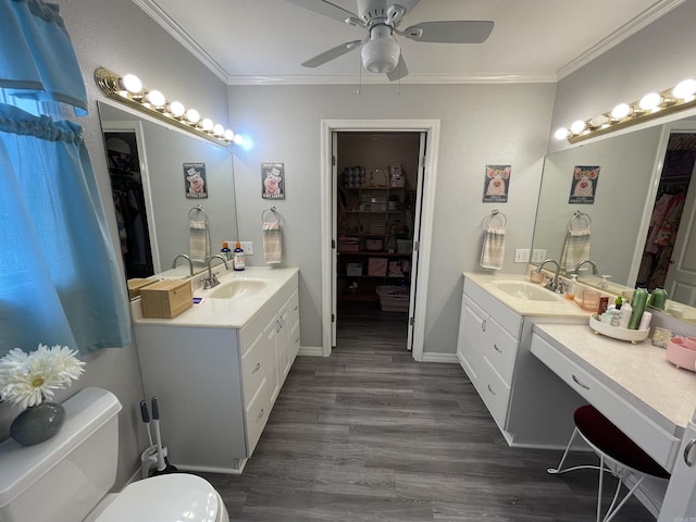 142 Timber Ridge Ln, El Dorado, AR 71730 - bathroom with ornamental molding, toilet, two vanities, ceiling fan, and a spacious closet