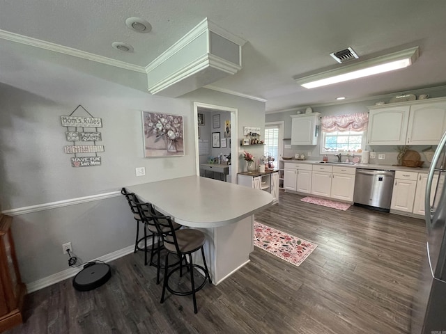 142 Timber Ridge Ln, El Dorado, AR 71730 - kitchen featuring stainless steel appliances, ornamental molding, a peninsula, white cabinetry, and a breakfast bar