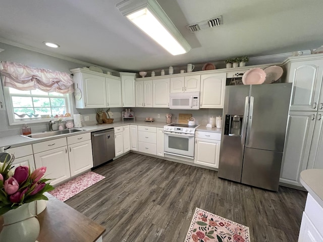 142 Timber Ridge Ln, El Dorado, AR 71730 - kitchen with stainless steel appliances, a sink, light countertops, dark wood-style floors, and white cabinetry