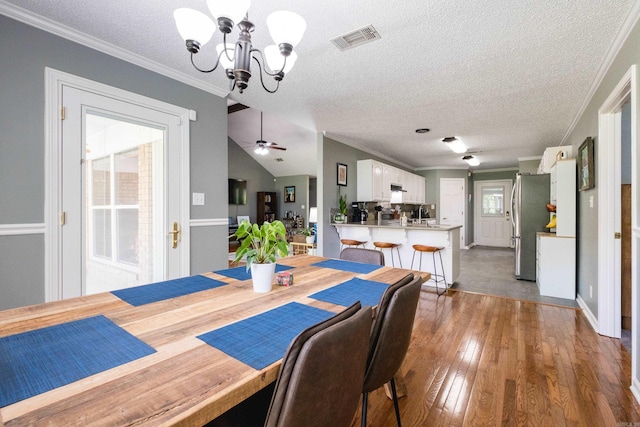 11 Blue Mountain Dr, Maumelle, AR 72113 - dining room with a chandelier, a textured ceiling, ornamental molding, hardwood / wood-style flooring, and baseboards