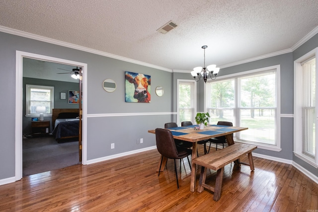 11 Blue Mountain Dr, Maumelle, AR 72113 - dining space featuring a chandelier, a textured ceiling, hardwood / wood-style floors, crown molding, and healthy amount of natural light