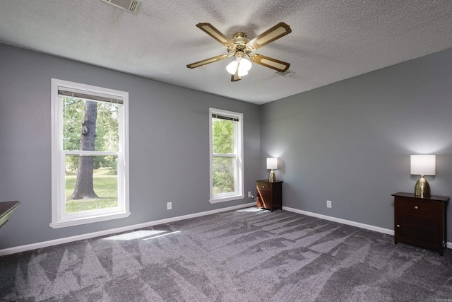11 Blue Mountain Dr, Maumelle, AR 72113 - spare room featuring plenty of natural light, dark colored carpet, a textured ceiling, a ceiling fan, and baseboards
