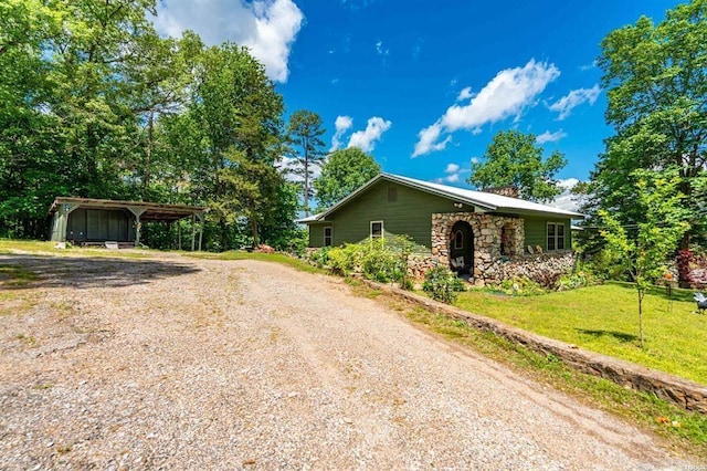 4915 Albert Pike Rd, Hot Springs, AR 71913 - view of property exterior with dirt driveway, a detached carport, stone siding, a yard, and a chimney