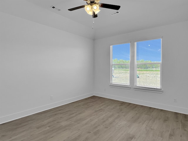 spare room with wood finished floors, baseboards, and ceiling fan