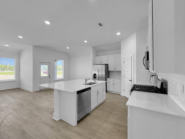 kitchen with appliances with stainless steel finishes, a sink, light wood-style flooring, an island with sink, and recessed lighting