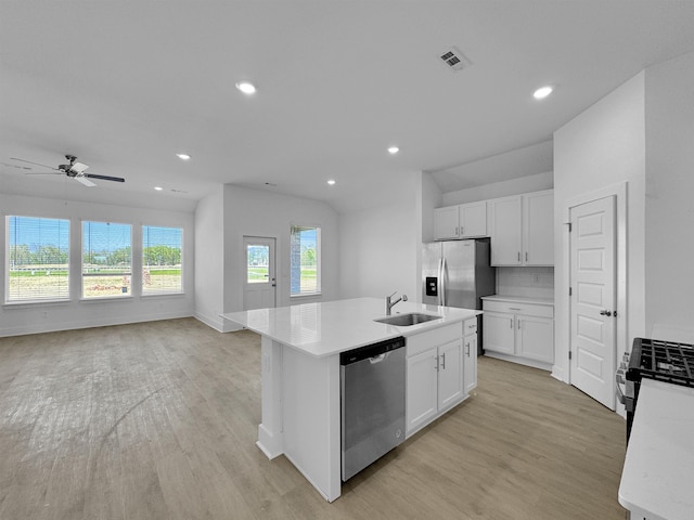 kitchen featuring appliances with stainless steel finishes, a sink, light wood finished floors, an island with sink, and recessed lighting