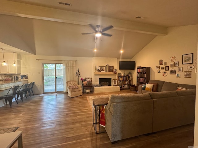 living area with dark wood-type flooring, ceiling fan, and a fireplace