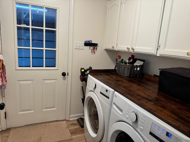 laundry area featuring cabinet space, washing machine and dryer, light wood-style flooring, and baseboards