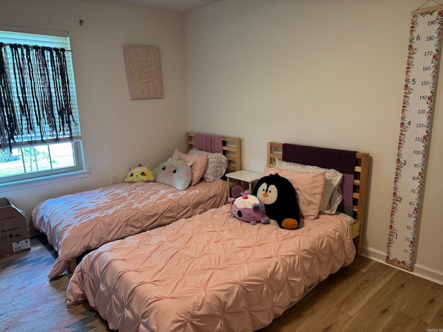 bedroom featuring wood finished floors and baseboards