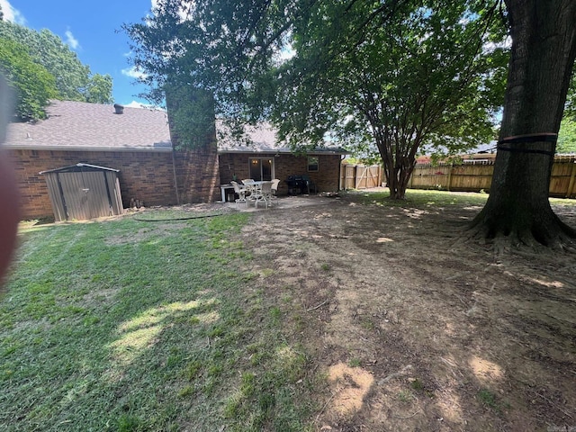 view of yard featuring a shed, an outbuilding, and a patio