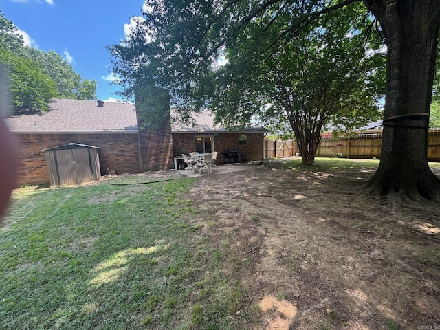 view of yard with a shed, an outbuilding, and a patio
