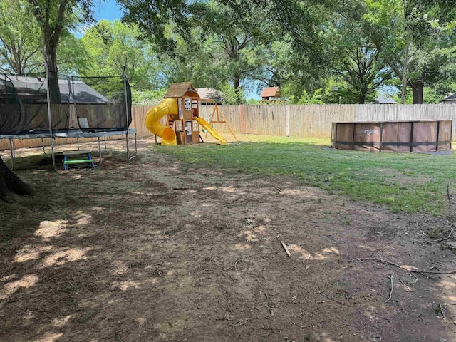 view of yard featuring a trampoline and a playground