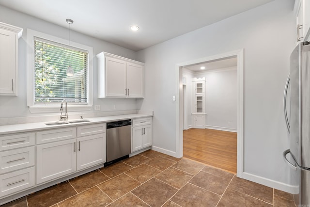 111 Midland St, Little Rock, AR 72205 - kitchen with appliances with stainless steel finishes, a sink, white cabinetry, light countertops, and decorative light fixtures