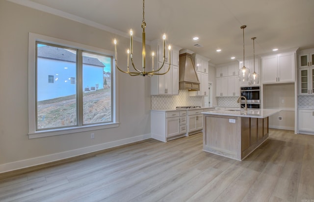 173 Maumelle Valley Dr, Maumelle, AR 72113 - kitchen featuring custom exhaust hood, light countertops, light wood finished floors, tasteful backsplash, and a chandelier