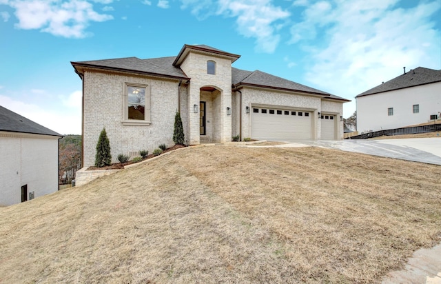 173 Maumelle Valley Dr, Maumelle, AR 72113 - french country style house with brick siding, a garage, concrete driveway, and a front lawn