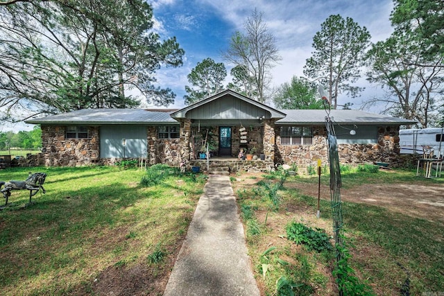 ranch-style house with stone siding, a porch, a front lawn, and metal roof