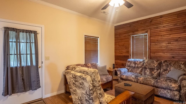 618 N 9th St, Thayer, MO 65791 - living room with crown molding, ceiling fan, wood walls, wood finished floors, and baseboards