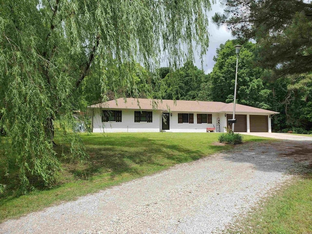 800 Hilltop Dr, Piggott, AR 72454 - ranch-style house with gravel driveway, a garage, and a front lawn