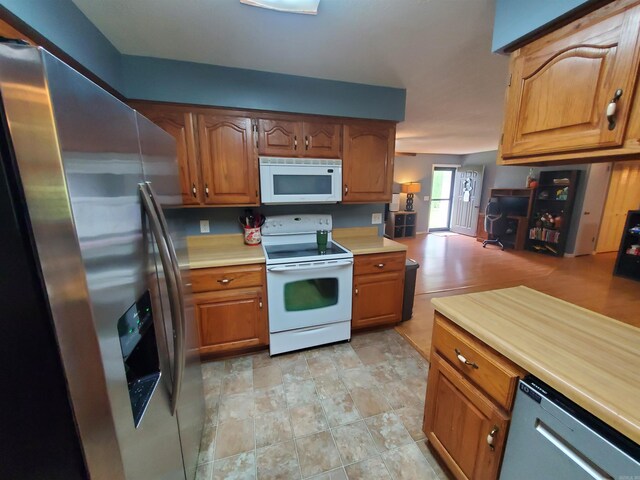 800 Hilltop Dr, Piggott, AR 72454 - kitchen with stainless steel appliances, light countertops, and brown cabinets