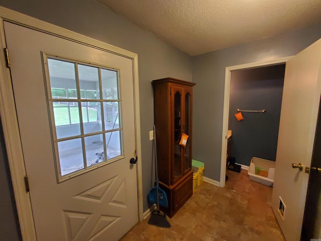 800 Hilltop Dr, Piggott, AR 72454 - doorway featuring a textured ceiling and baseboards