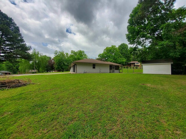 800 Hilltop Dr, Piggott, AR 72454 - view of yard with an outbuilding, a storage shed, view of wooded area, and a garage