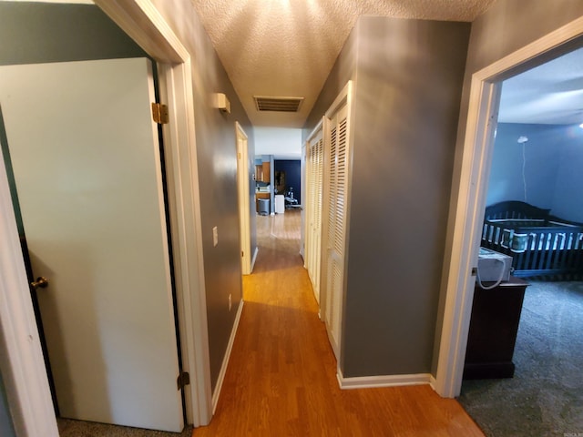 800 Hilltop Dr, Piggott, AR 72454 - hallway featuring wood finished floors, baseboards, and a textured ceiling