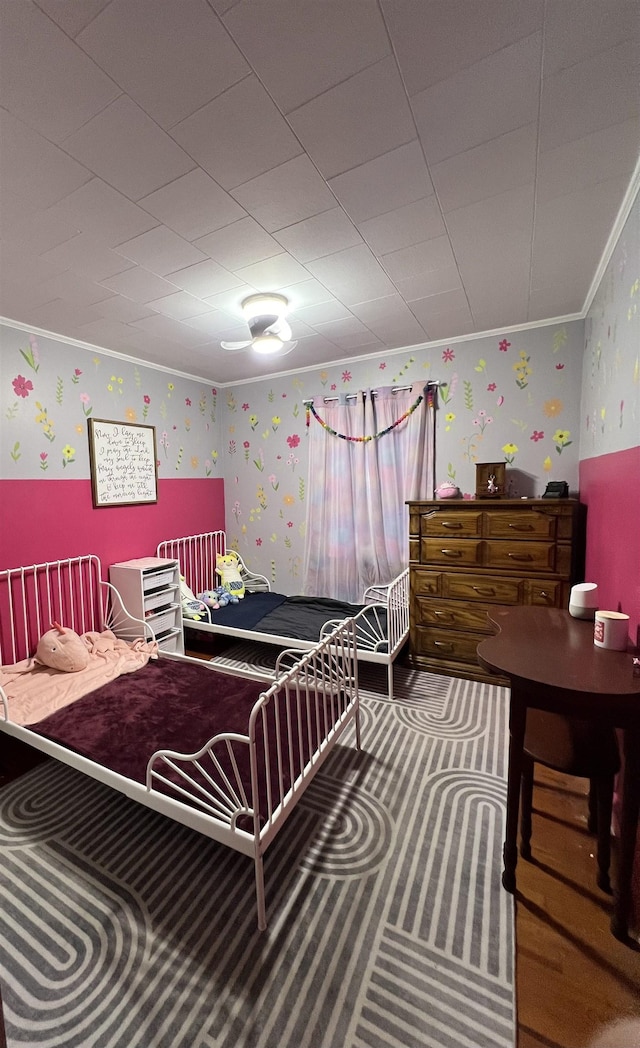bedroom with wallpapered walls and crown molding