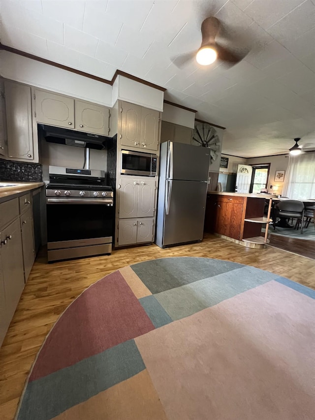 kitchen featuring stainless steel appliances, ceiling fan, under cabinet range hood, gray cabinetry, and light wood-type flooring