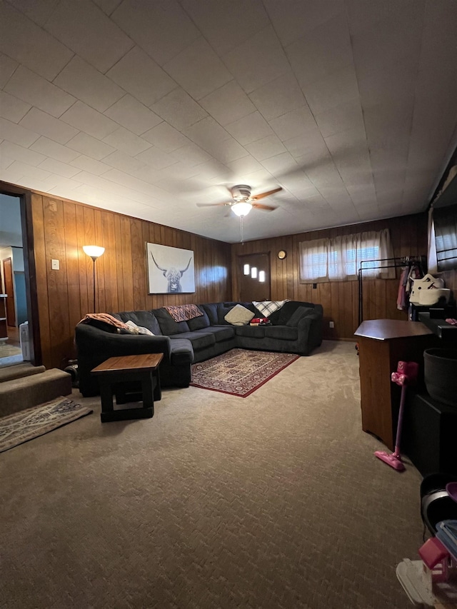 carpeted living room with wooden walls and a ceiling fan