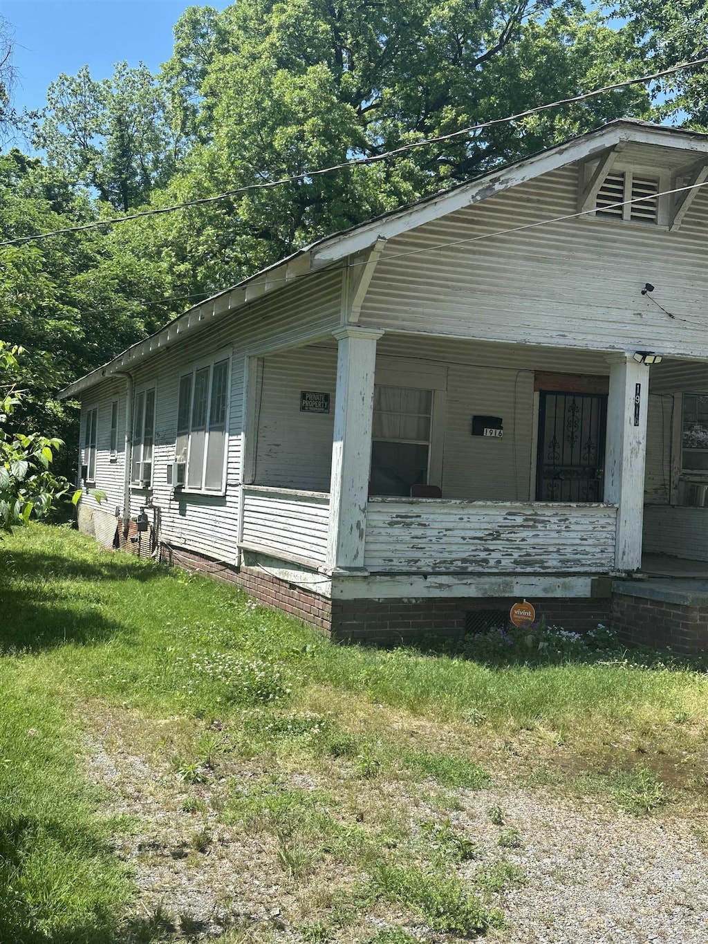 view of side of property with covered porch and a lawn