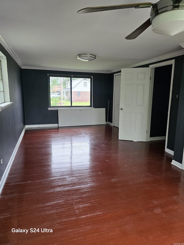 unfurnished bedroom with ornamental molding, wood finished floors, baseboards, and a ceiling fan