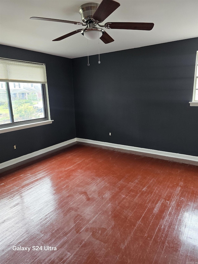 empty room featuring wood finished floors, ceiling fan, and baseboards