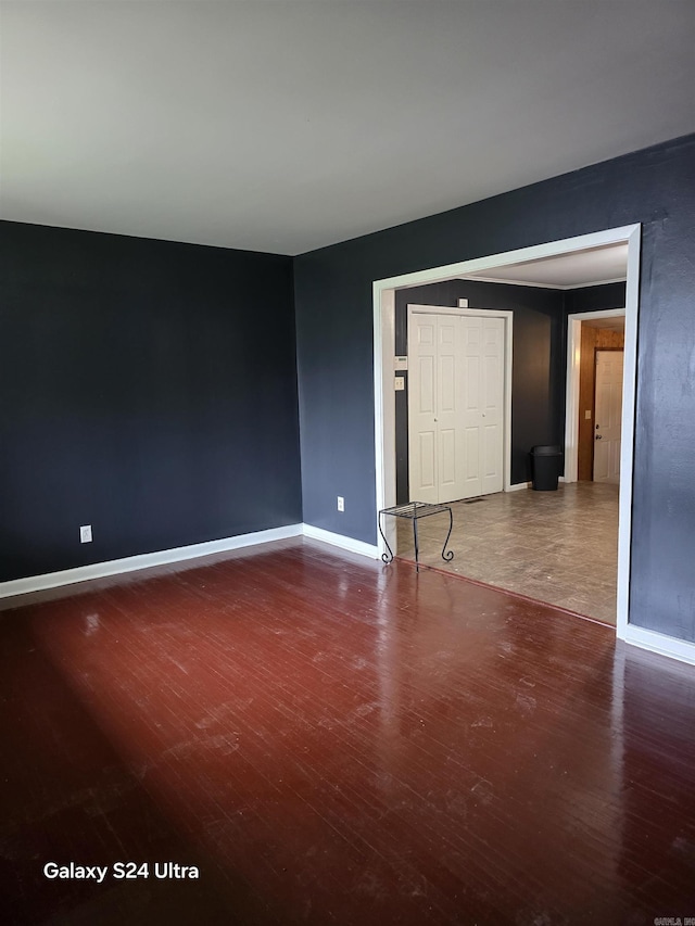 empty room featuring wood finished floors and baseboards