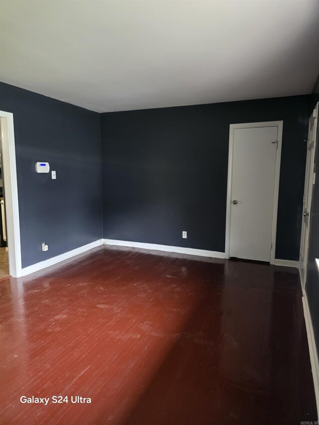 unfurnished room featuring wood finished floors and baseboards