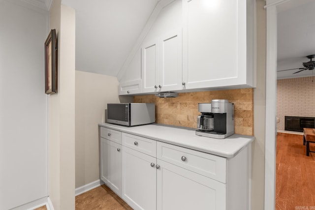 8 Cannon Ct, Little Rock, AR 72212 - kitchen with stainless steel microwave, light countertops, decorative backsplash, white cabinets, and ceiling fan