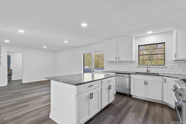 716 Vinson, Little Rock, AR 72205 - kitchen featuring a sink, appliances with stainless steel finishes, dark wood-type flooring, dark stone counters, and tasteful backsplash