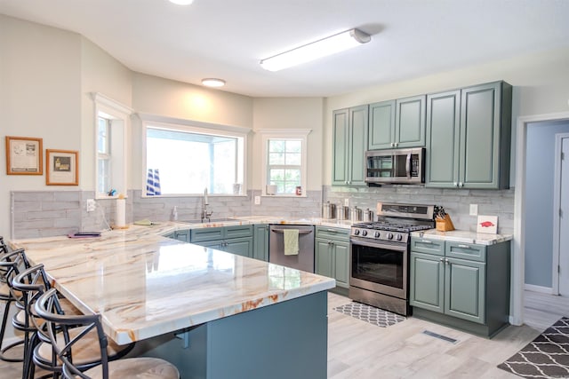 47 Lakeview Rd, Houston, AR 72070 - kitchen featuring stainless steel appliances, a peninsula, a sink, a kitchen breakfast bar, and decorative backsplash