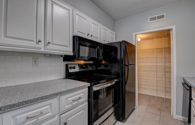700 E 9th St Unit 9A, Little Rock, AR 72202 - kitchen with stainless steel range with electric stovetop, black microwave, backsplash, white cabinets, and a textured ceiling