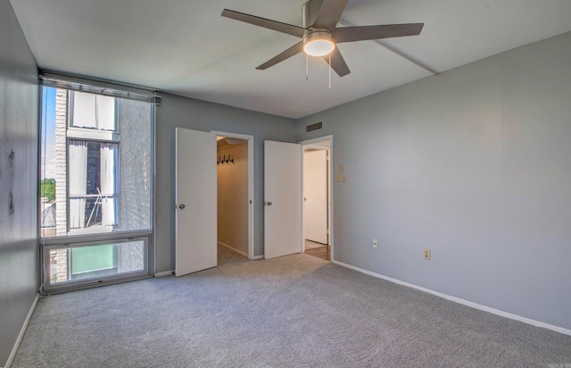 700 E 9th St Unit 9A, Little Rock, AR 72202 - unfurnished bedroom featuring carpet flooring, multiple windows, baseboards, and ceiling fan