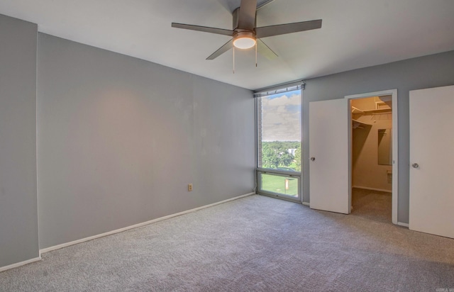 700 E 9th St Unit 9A, Little Rock, AR 72202 - unfurnished bedroom with carpet, a walk in closet, ceiling fan, baseboards, and a closet