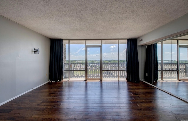 700 E 9th St Unit 9A, Little Rock, AR 72202 - spare room with a textured ceiling, hardwood / wood-style flooring, baseboards, and expansive windows