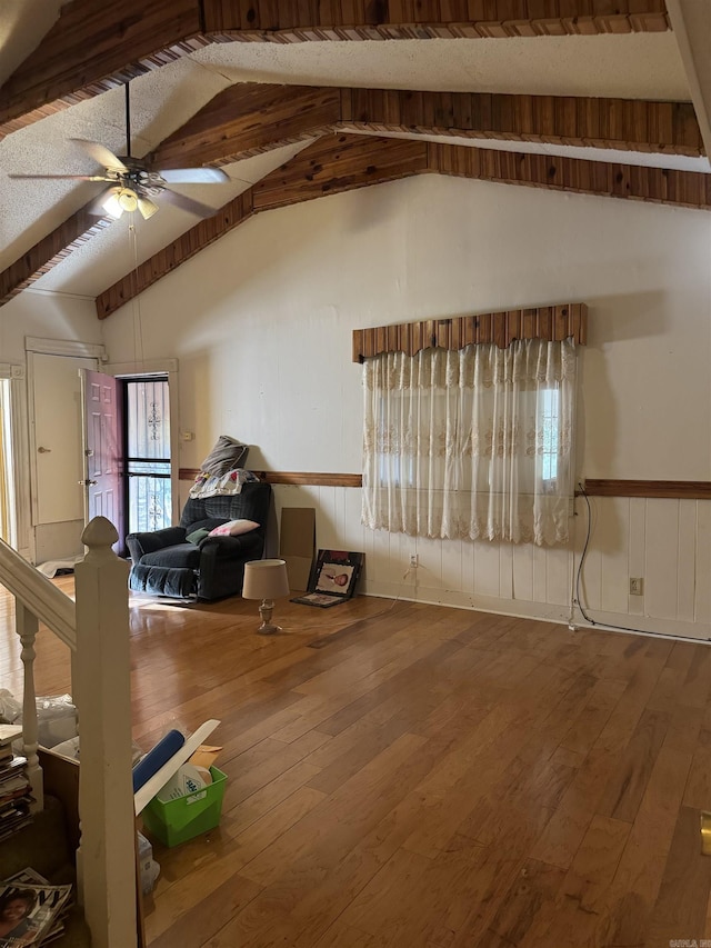 bonus room featuring ceiling fan, wood-type flooring, and a wainscoted wall