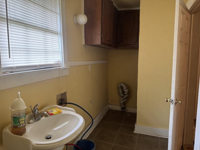 bathroom featuring a sink, tile patterned floors, and baseboards