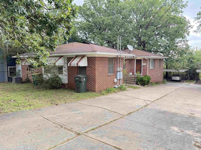 215217 N Pierce St, Little Rock, AR 72205 - view of front facade featuring brick siding, a carport, a front lawn, concrete driveway, and central AC