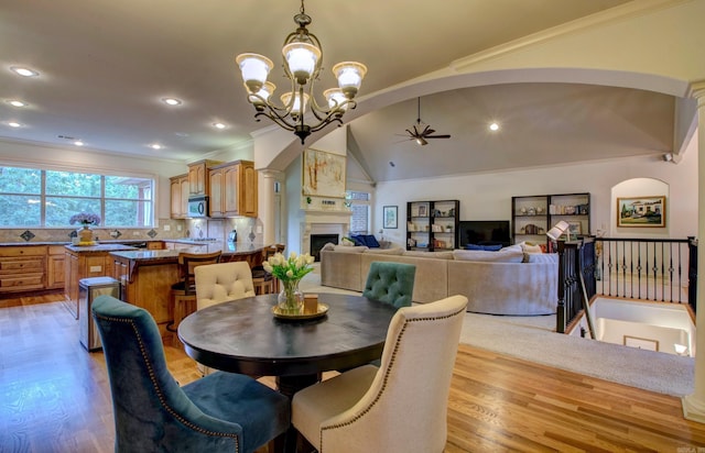 32 Bronte Ct, Little Rock, AR 72223 - dining space with ceiling fan, light wood-type flooring, a chandelier, ornamental molding, and a fireplace