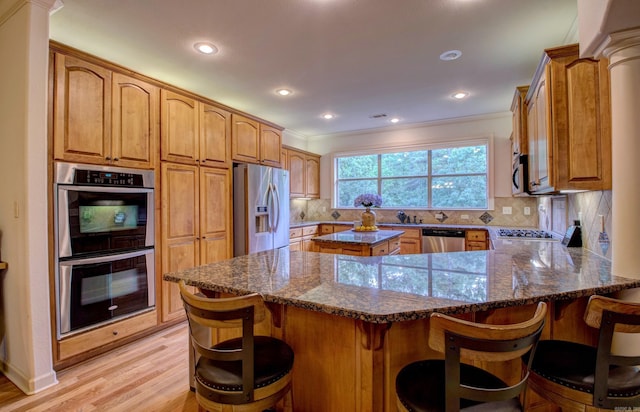 32 Bronte Ct, Little Rock, AR 72223 - kitchen featuring stainless steel appliances, light wood-type flooring, dark stone countertops, decorative backsplash, and a peninsula