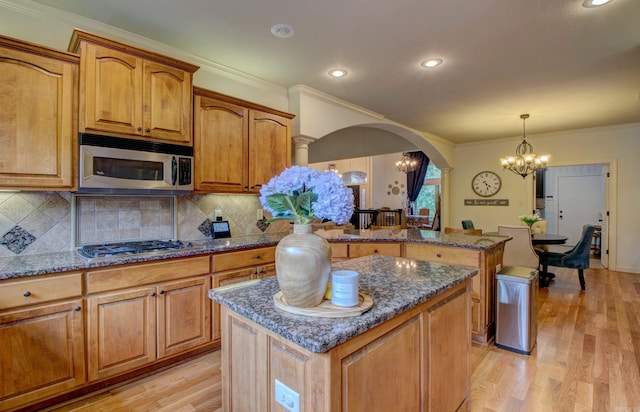32 Bronte Ct, Little Rock, AR 72223 - kitchen with appliances with stainless steel finishes, a chandelier, arched walkways, a center island, and light wood-style floors